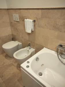 a bathroom with a toilet and a sink and a tub at Villa Spaccasole su Cortona in Foiano della Chiana