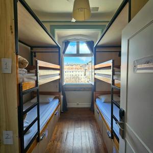 a room with three bunk beds and a window at Rossio Hostel in Lisbon