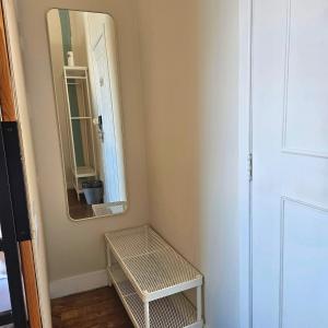 a small bathroom with a mirror and a stool at Rossio Hostel in Lisbon
