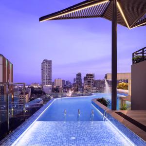 uma piscina no topo de um edifício com um horizonte da cidade em Chaiya Palace Hotel em Phnom Penh