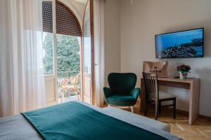 a bedroom with a bed and a desk and a window at Hotel Bellevue in Gardone Riviera