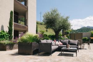 a patio with a couch and a table and chairs at Weingut & Genusshotel Spitalerhof Superior in Chiusa