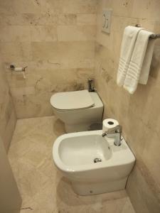 y baño con aseo blanco y lavamanos. en Villa Spaccasole su Cortona en Foiano della Chiana
