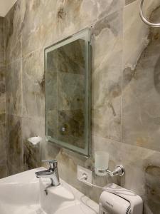 a bathroom with a sink and a mirror at Oda Garden Boutique Hotel in Tirana