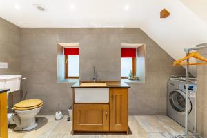 a bathroom with a toilet and a washer and dryer at Old Farmhouse in Hawkshead +26 photos