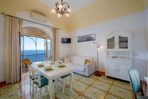 uma sala de estar com uma mesa e um sofá em Flatiron app 1 by Sosòre Holiday Homes - Amalfi Coast em Praiano
