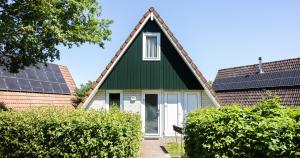 a house with a green roof with solar panels at Bungalows in het Holt in Gramsbergen