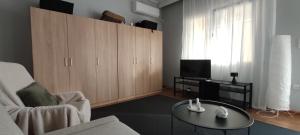 a living room with a couch and a table and a tv at Letos Apartment Sky in Kavála