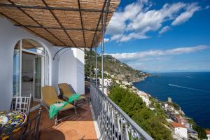 uma varanda com cadeiras e vista para o oceano em Flatiron app 1 by Sosòre Holiday Homes - Amalfi Coast em Praiano