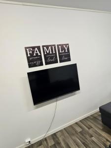 una TV a schermo piatto su una parete bianca di TromsøApartment Silent area with free parking I have caravan for rent same place, 4 people a Tromsø