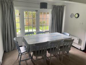 a dining room with a table and chairs and windows at Tudor Cottage Hayle - a Family & Pooch Favourite in Hayle