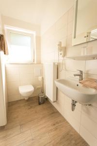 bagno bianco con lavandino e servizi igienici di Hotel Restaurant Ketterer am Kurgarten a Triberg