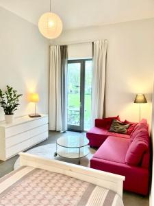 sala de estar con sofá rojo y mesa de cristal en Historisches Designer Loft en Essen