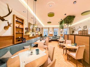 Hotel Elefant Family Business في سالزبورغ: مطعم فيه طاولات وكراسي في الغرفة