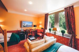 a bedroom with orange walls and a bed and a couch at Hotel Mittelweg in Hamburg