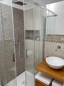 a bathroom with a glass shower and a sink at Villa Elma in Villaputzu