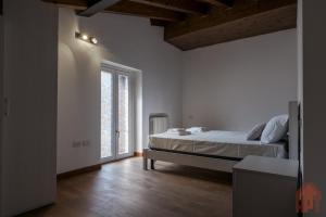 a bedroom with a bed and a large window at Duplex open space with private courtyard in center in Desenzano del Garda