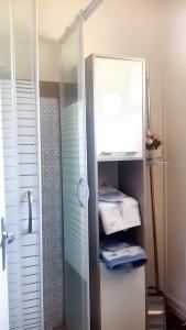 uma casa de banho com chuveiro e um armário com toalhas em Maison d'une chambre avec jardin clos et wifi a La Croix en Touraine em La Croix-en-Touraine