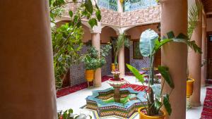 ein Innenhof mit Pflanzen in einem Gebäude in der Unterkunft Hotel imouzzer in Marrakesch