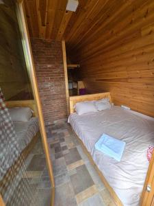 - une chambre avec un lit dans une cabane en bois dans l'établissement Peaks of Prokletije, à Gusinje