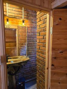 een badkamer met een bakstenen muur en een wastafel bij Peaks of Prokletije in Gusinje
