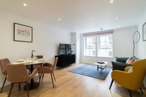 a living room with a table and a couch at PREMIER SUITES Edinburgh Fountain Court in Edinburgh