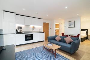 a living room with a blue couch and a table at PREMIER SUITES Edinburgh Fountain Court in Edinburgh