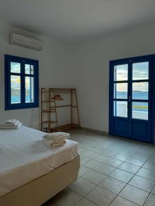 Lipsi Blue Hotel في ليبسوي: غرفة نوم بسرير ونوافذ وسلالم