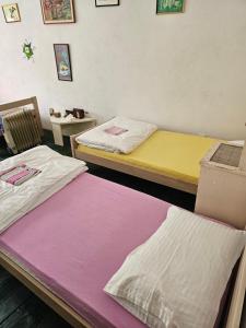 two beds in a room with purple and yellow at Hostel Ka Doma in Cetinje