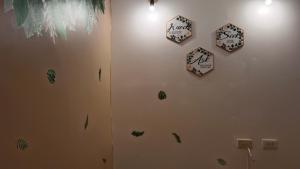 a wall with clocks on it with leaves on it at Maligaya Maison in General Luna