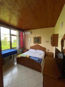 1 dormitorio con cama, mesa y ventana en Villa Mance, en Berat