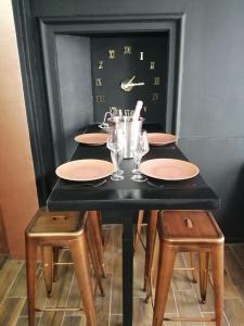 una mesa negra con sillas, platos y vasos en Appartements avec balnéo et sauna privatif - Troyes Centre, en Troyes 9 fotos más