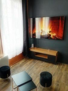 Una sala de estar con chimenea y una mesa y sillas. en Appartements avec balnéo et sauna privatif - Troyes Centre, en Troyes