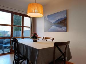 a dining room table with a vase of flowers on it at Inmocyma La terraceta de Linsoles-Valle de Benasque in Benasque