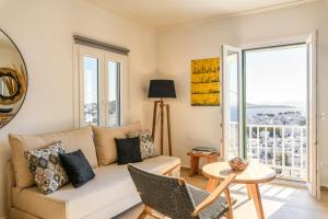 a living room with a couch and a table at Blueisla Sea View Suite A in Mikonos