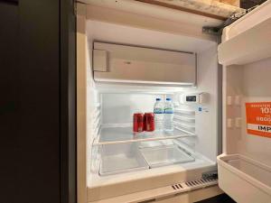 an open refrigerator with bottles of water and soda at Private Holiday Home, Great Location in Brighton & Hove +5 photos