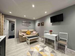 a living room with a couch and a tv at Private Holiday Home, Great Location in Brighton & Hove