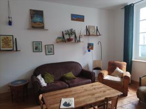 een woonkamer met een bank en een tafel bij Maison familiale en centre-ville in Rochefort