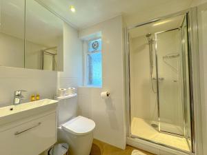 a bathroom with a shower and a toilet and a sink at Primestate Hyde Park Apartments in London