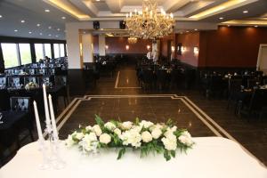 um salão de banquetes com uma mesa com flores brancas em BM HOTEL City em Samsun