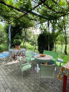 een patio met een tafel en stoelen en een open haard bij Villa Mance in Berat