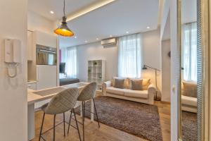 cocina y sala de estar con mesa y sillas en ZigZag Belgrade, en Belgrado