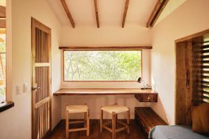 Habitación pequeña con 2 taburetes y ventana en Hostel Clandestino Maderas, en El Plantel
