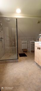 a bathroom with a shower with a glass door at La Poserie des Monts et Vallées in Esson +41 photos