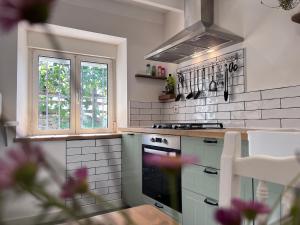 a white kitchen with a stove and a window at Casa con vistas a la montaña, cerca a la costa entre Arriondas y Ribadesella in Cangas de Onís