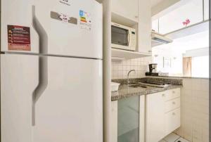 a white refrigerator in a kitchen with white cabinets at Belo apartamento Perdizes em frente o Allianz Parque com estacionamento in São Paulo