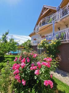 un ramo de flores rosas delante de un edificio en Landhaus Forrás 2, en Balatonfüred