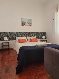a bedroom with two beds with orange pillows at Anchor House in Albufeira