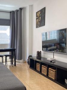 sala de estar con TV de pantalla plana en la pared en BKD1 - Apartamento entero a 50 metros PLAYA DE LAS CANTERAS, en Las Palmas de Gran Canaria
