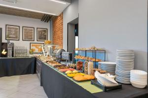 a buffet line with bread and pastries and plates at The Loop Hotel in Zagreb